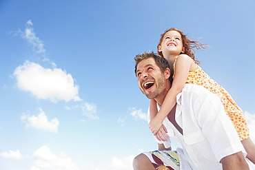 Father carrying daughter on shoulders