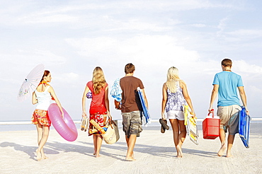 Friends walking with beach essentials