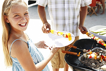 Man grilling dinner for family on beach