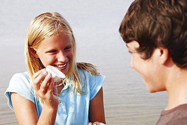 Girl showing shell to friend