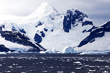 Snowcapped rock and ice floes, Antarctica
