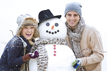 Portrait of couple with snowman