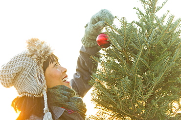 Smiling woman decorating Christmas tree