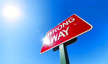 Low angle view of "wrong way" sign