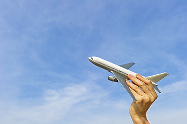 Woman's hand holding plane model