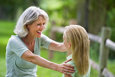 Girl (10-11) and grandmother laughing togetherness