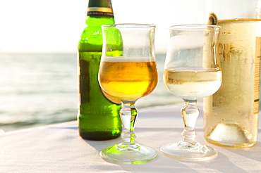 Greece, Cyclades Islands, Mykonos, Beer and wine on table by sea