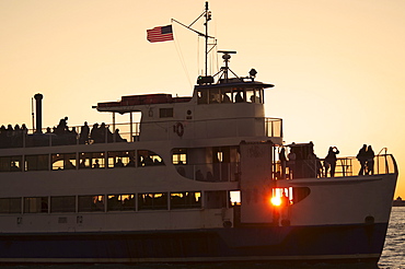 USA, New York City, Silhouette of passengers on tourboat