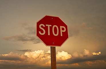 USA, South Dakota, Badlands National Park, Stop sign against sky at sunset