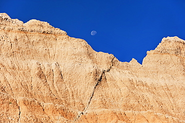 USA, South Dakota, Mountain against blue sky with moon in Badlands National Park