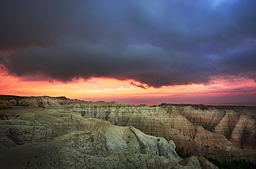 USA, South Dakota, Thick gray clouds over mountains in Badlands National Park at sunset