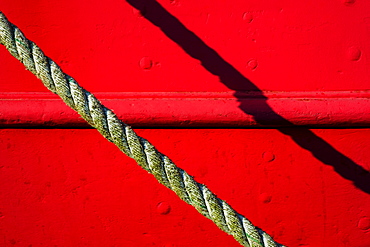 Detail of red tugboat with rope