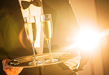 Waiter holding tray with champagne