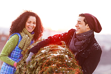 Couple carrying christmas tree