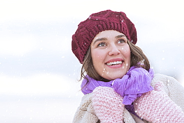 Portrait of young woman wearing knit hat, gloves and scarf