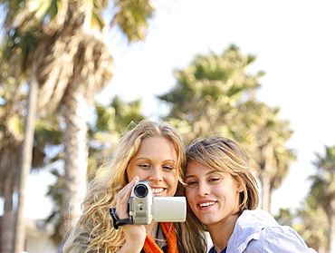 Two women looking at video camera