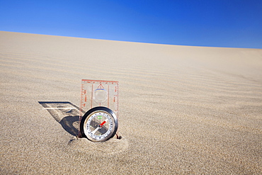 Oregon, Florence, Compass partially buried in sand