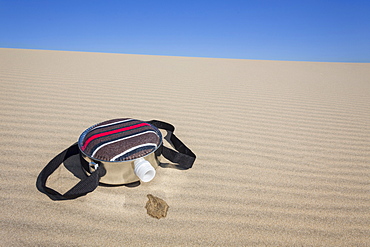 Oregon, Florence, Empty water bottle lying on sand dune