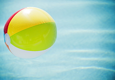 Close up of striped beach ball against water surface