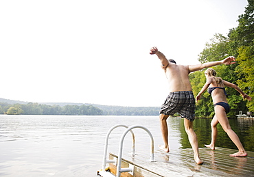 USA, New York, Putnam Valley, Roaring Brook Lake, Couple about to jump from pier to lake