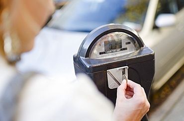 USA, New York State, New York City, Brooklyn, Woman inserting coin into parking meter