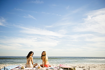 Two women relaxing on beach, Rockaway Beach, New York