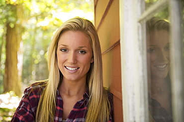 Portrait of young woman standing in front of house, Newtown, Connecticut