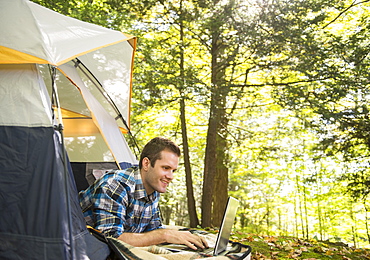 Man using laptop outside tent, Newtown, Connecticut