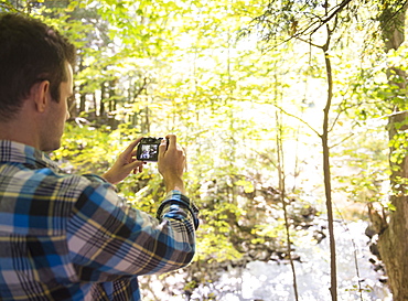 Man taking picture in forest, Newtown, Connecticut