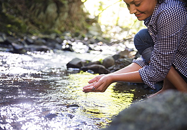 Woman crouching by stream, Newtown, Connecticut