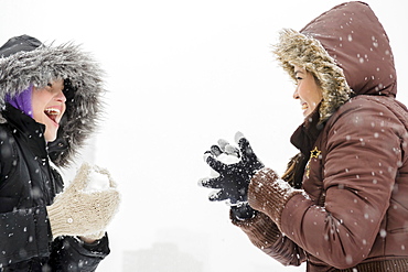 Two young women having snowball flight 