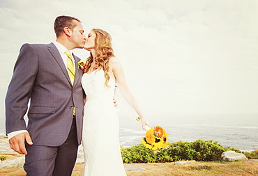 Portrait of married couple kissing, sea in background, USA, Maine, Bristol 