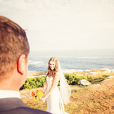 Groom looking at bride, sea in background, USA, Maine, Bristol 