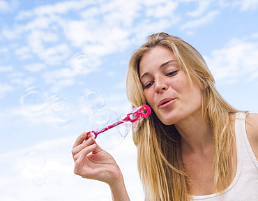 Young woman blowing bubbles