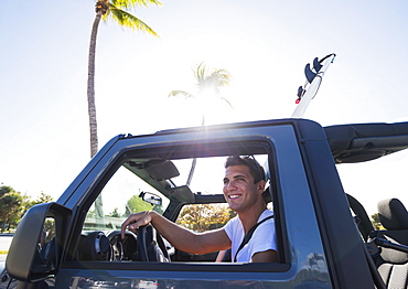 Young man driving car, Jupiter, Florida, USA