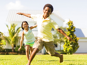 girl (8-9) and boy (6-7) playing on front yard, Jupiter, Florida