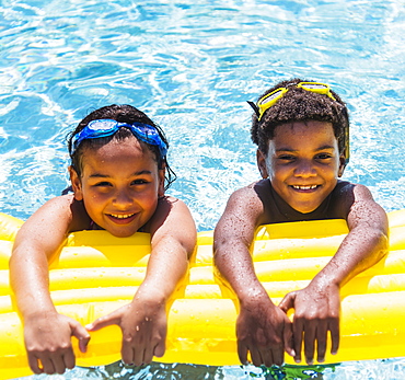 Portrait of kids( 6-7, 8-9) with pool raft