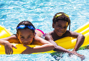 Portrait of kids( 6-7, 8-9) with pool raft