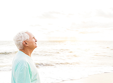 Side view of senior man smiling on beach, Jupiter, Florida