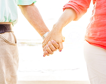 Couple holding hands on beach, Jupiter, Florida