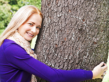 USA, New York, New York City, Manhattan, Central Park, Young woman embracing tree