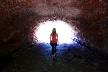 USA, New York, New York City, Manhattan, Central Park, Young woman walking in tunnel