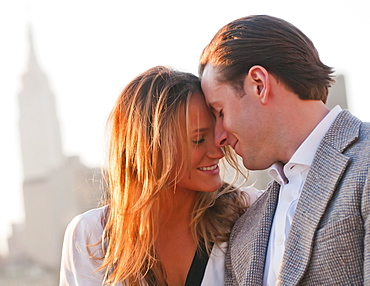 USA, New York, Long Island City, Close-up of happy young couple, Manhattan skyline in background