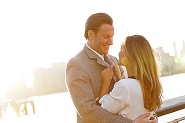 USA, New York, Long Island City, Young couple flirting on bridge, Manhattan skyline in background