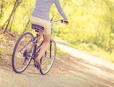 Mid adult woman riding bicycle, low section, Central Park, New York City