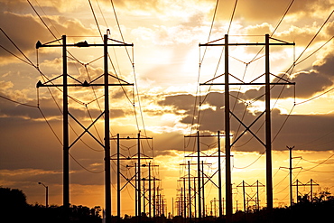 Electrical poles and wires at sunset