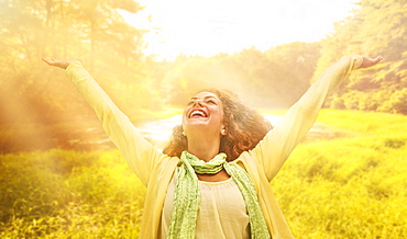 Woman reaching up to sunrays