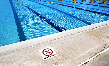 No diving sign on edge of swimming pool