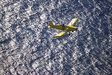 Small airplane ascending over water