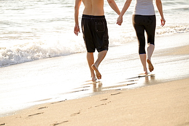 Couple walking on beach, low section, Palm Beach, Florida